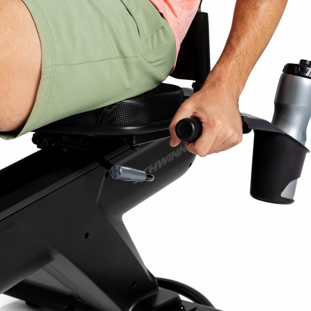 Gros plan du vélo d'exercice. Logo Schwinn et porte-bouteille visibles.