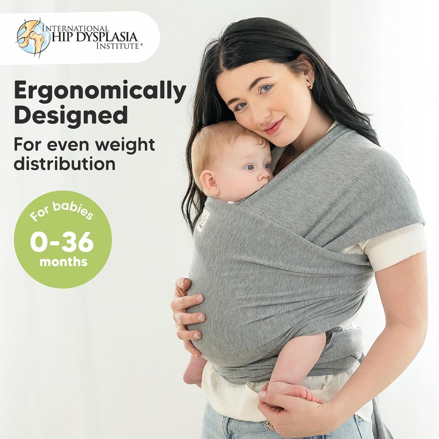 Graues KeaBabies Babytragetuch, ergonomisch gestaltet für eine gleichmäßige Gewichtsverteilung. Geeignet für Babys von 0-36 Monaten. Das Tuch wird von einer Mutter getragen, die ein Baby hält.
