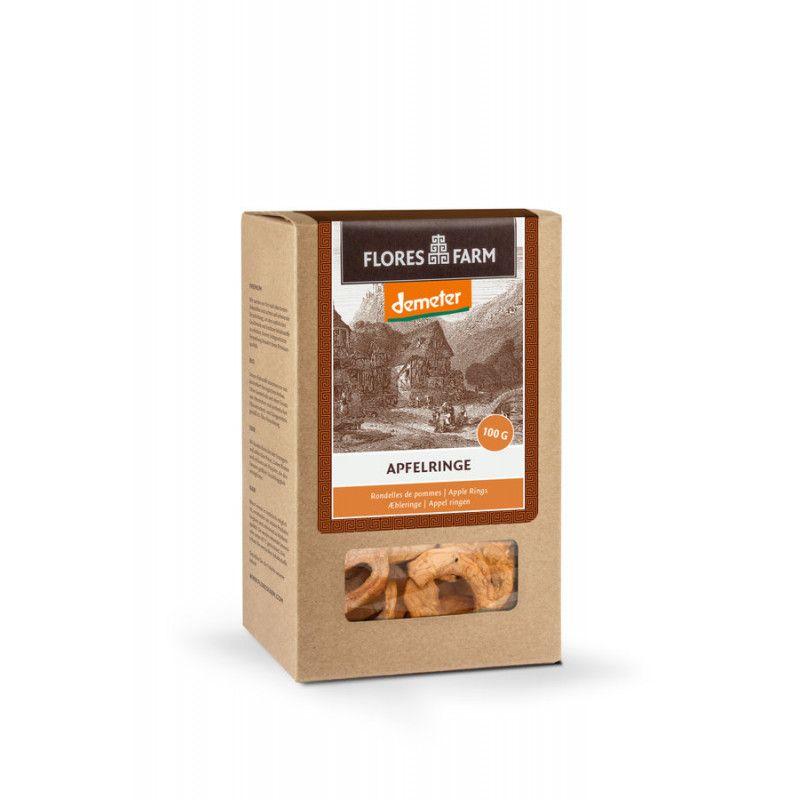 Kartonverpackung mit Apfelringen. Sichtfenster zeigt getrocknete Apfelstücke. Aufdruck: Flores Farm, Demeter-Logo, Apfelringe.