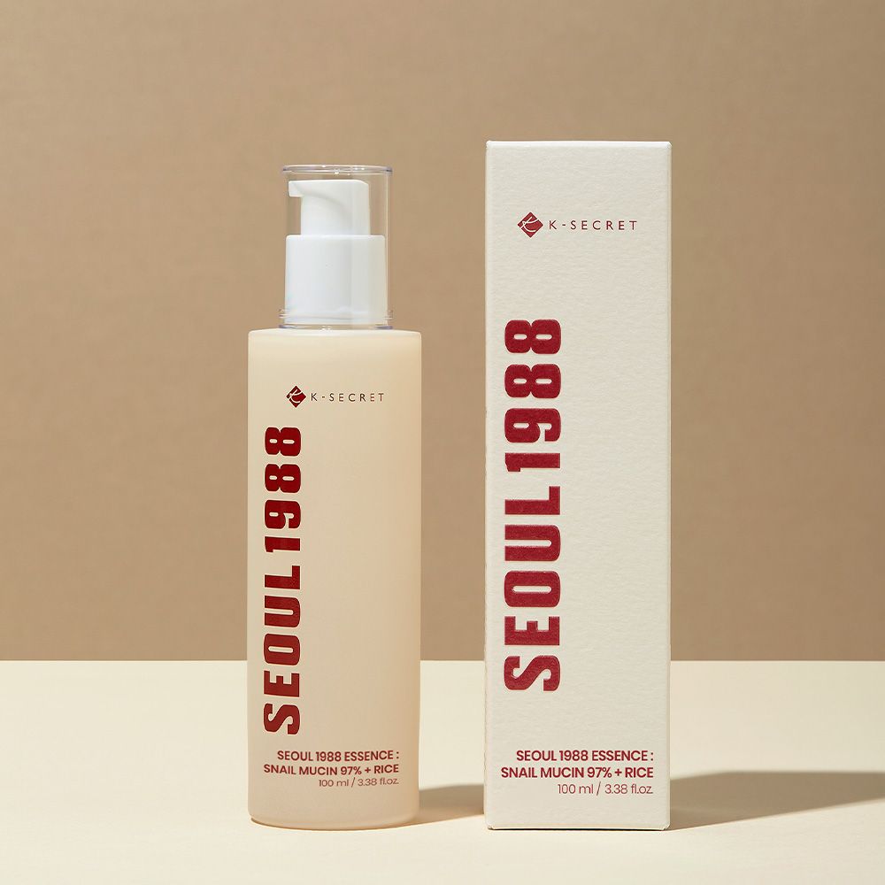 K-SECRET Seoul 1988 Essence Flakon und Kartonverpackung. Beige Flasche mit rotem Schriftzug.