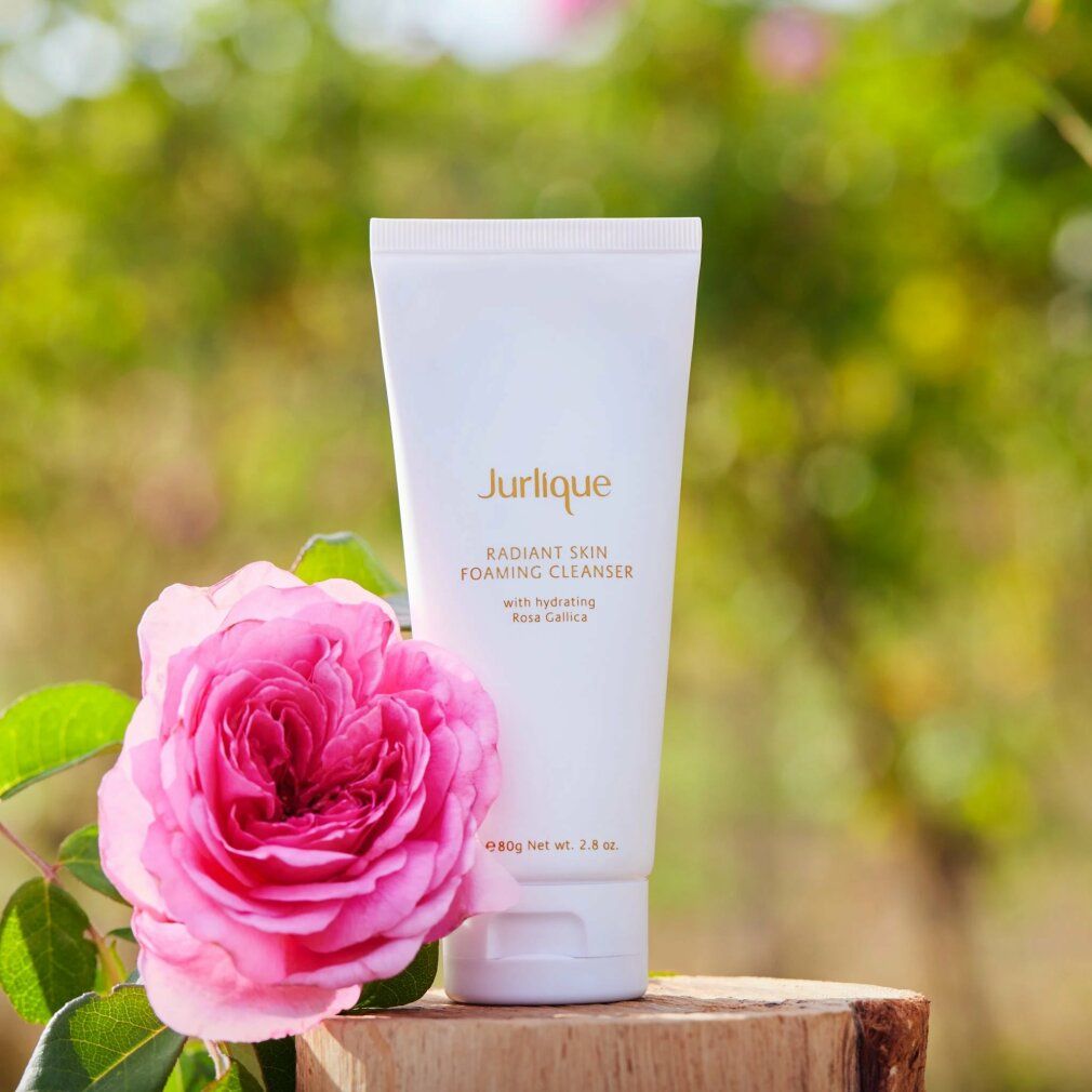 Jurlique Radiant Skin Foaming Cleanser neben einer rosa Rose.