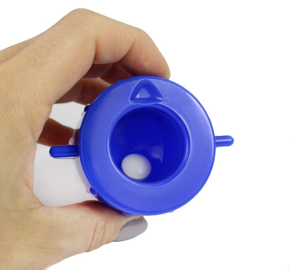 Blauer Tablettenmörser, geöffnet. Innenraum sichtbar. Eine Tablette.