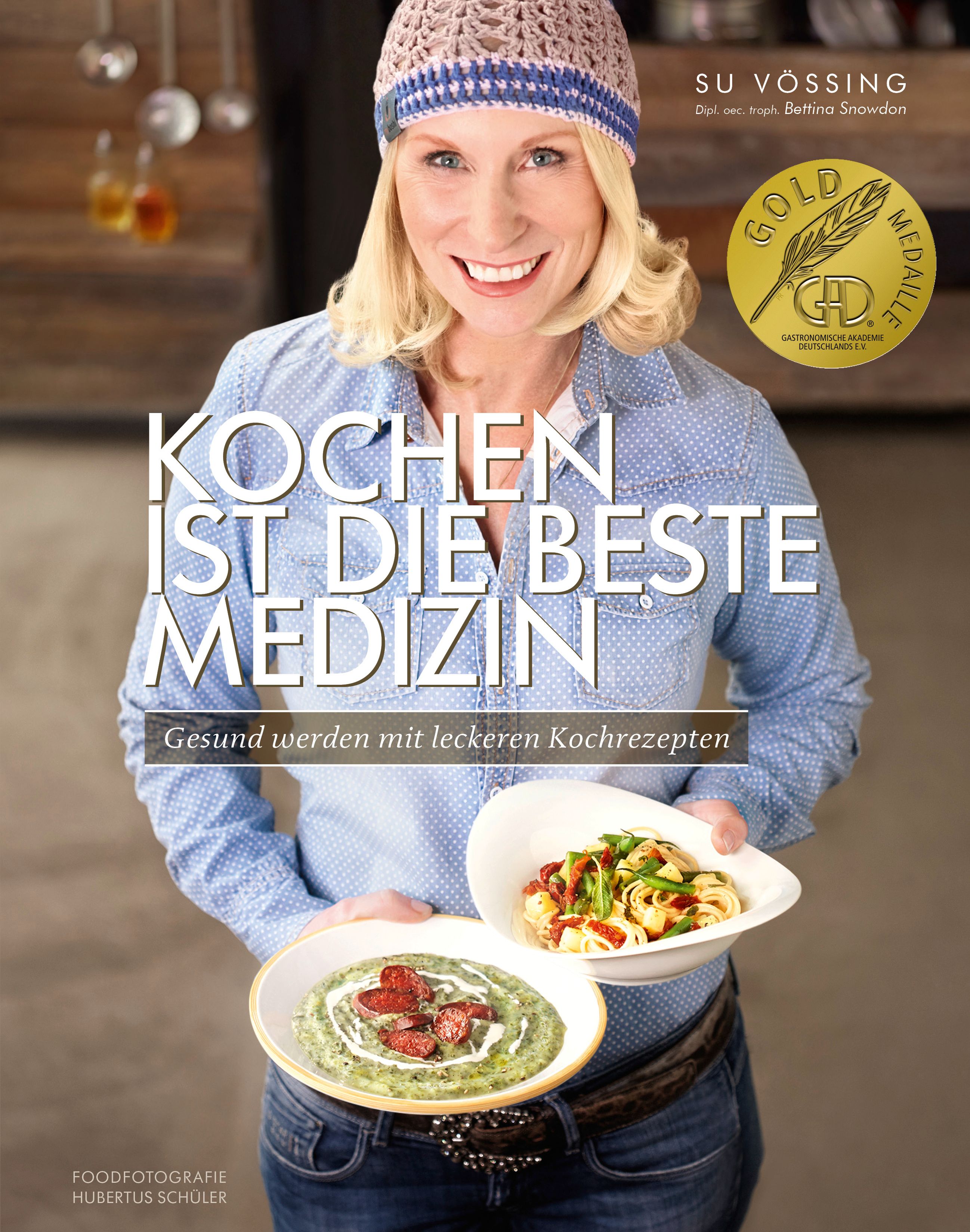 Buchcover: Kochen ist die beste Medizin. Frau hält zwei Teller mit Essen. Goldmedaille.