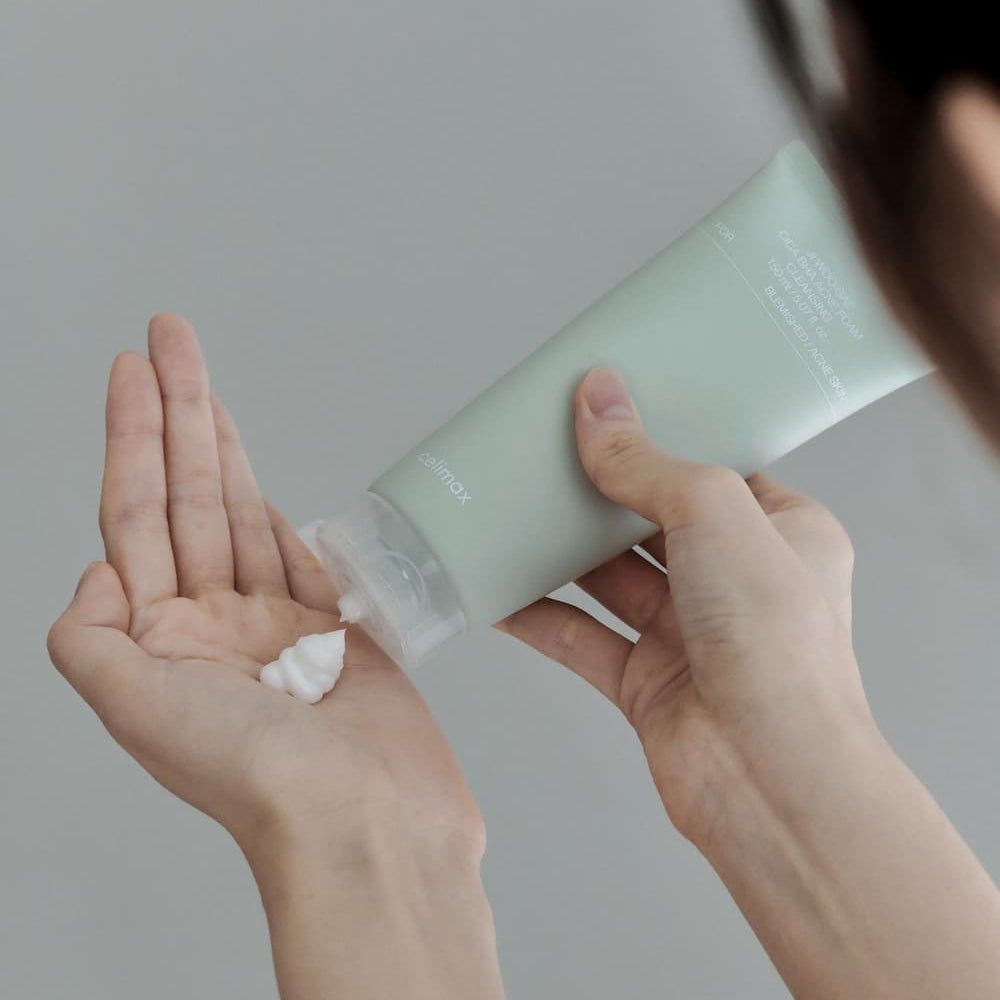Celimax Ji Woo Gae Cica BHA Akne-Reinigungsschaum wird in die Hand gegeben.