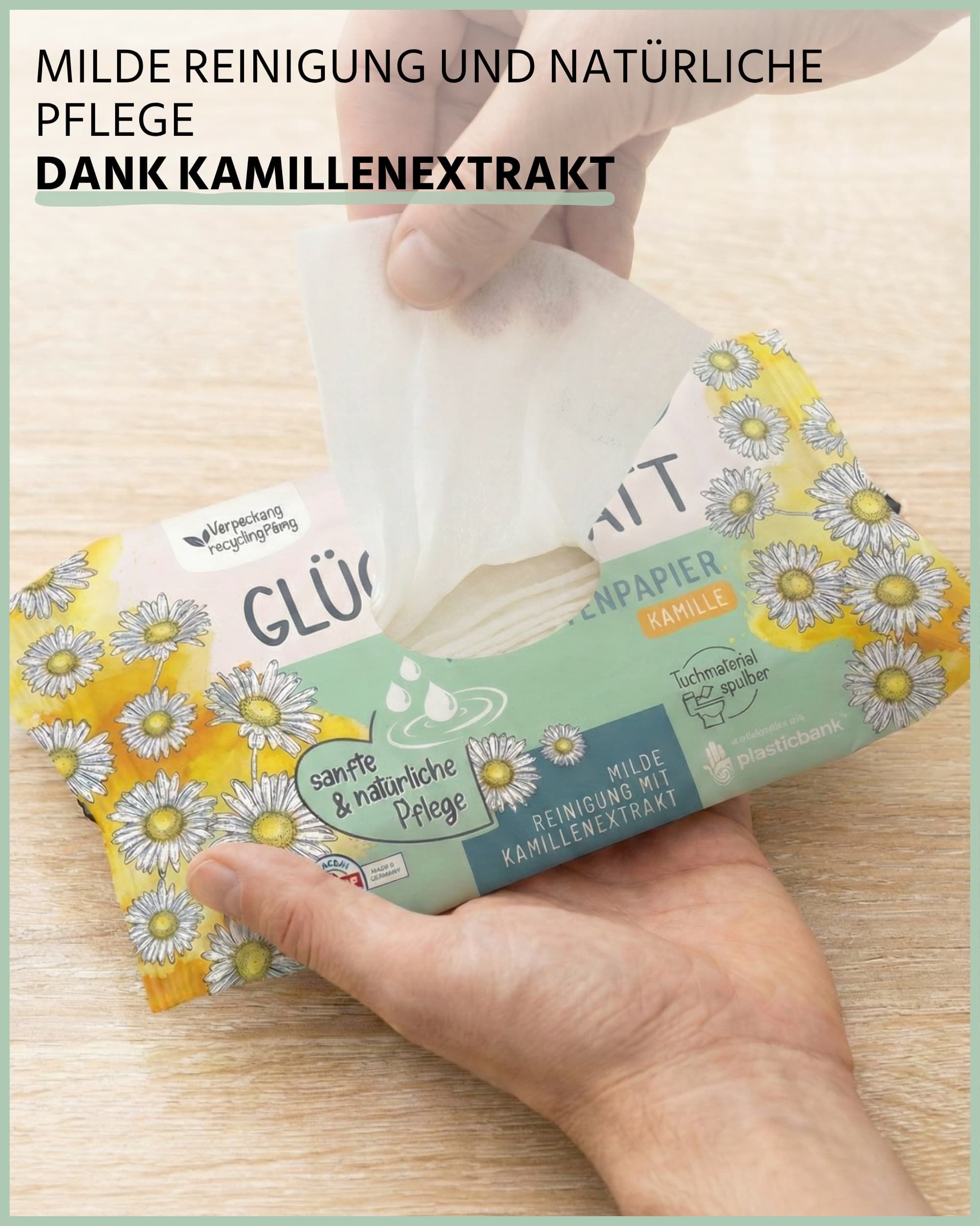 Hände halten Packung Feuchtes Toilettenpapier KAMILLE. Text: milde Reinigung und natürliche Pflege dank Kamillenextrakt. Weiße Tücher sichtbar.