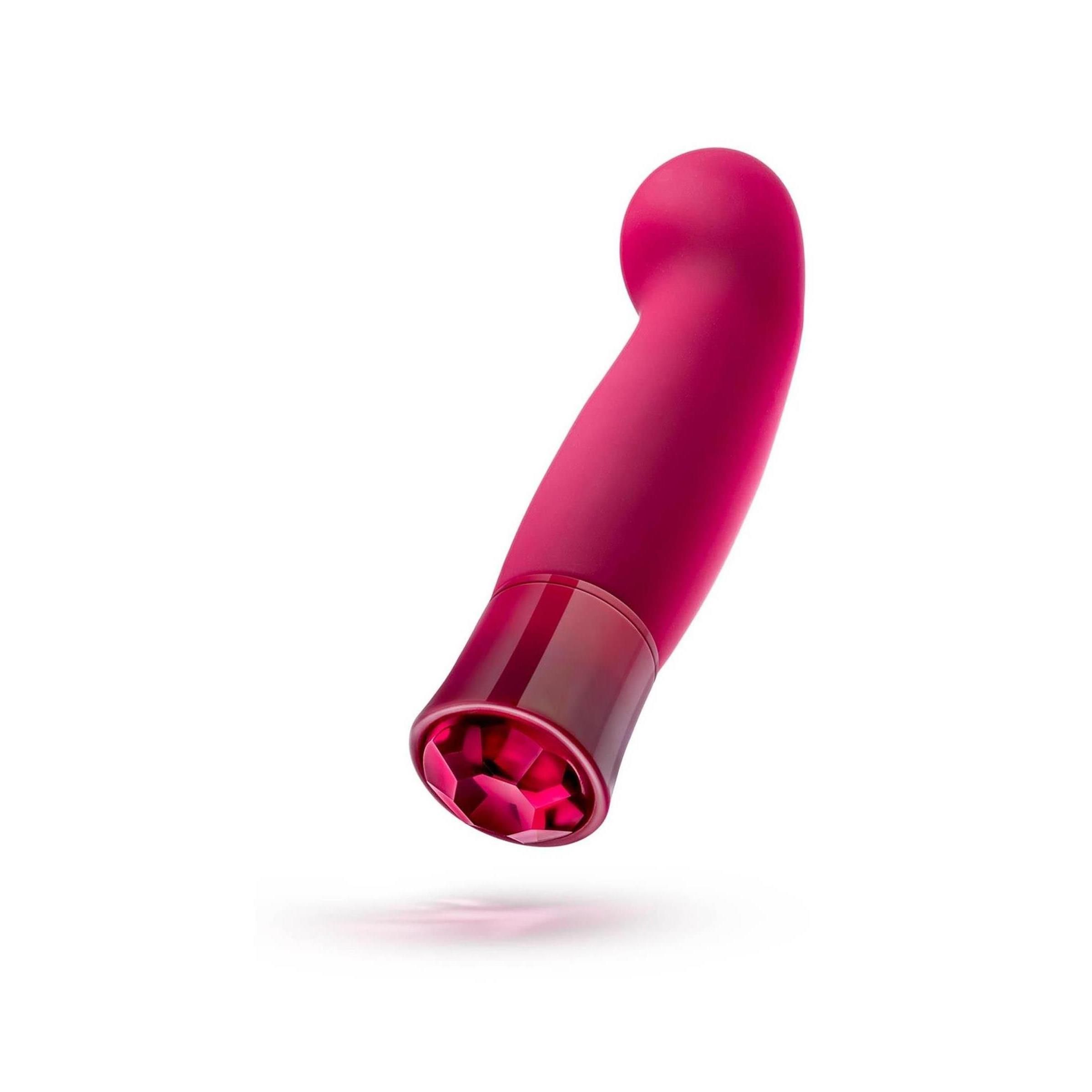 Ein gebogener Vibrator mit runder Spitze und Kristallfuß. Er schwebt leicht über einer Oberfläche.