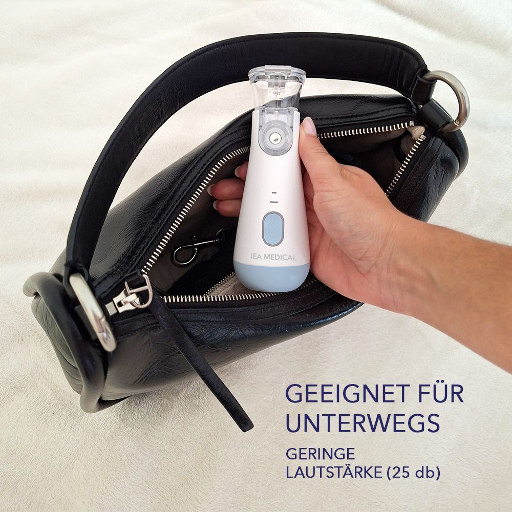 Inhalationsgerät in Handtasche. Weißes Gerät mit blauem Boden. Text: Geeignet für unterwegs. Geringe Lautstärke (25 db). IEA MEDICAL-Logo.