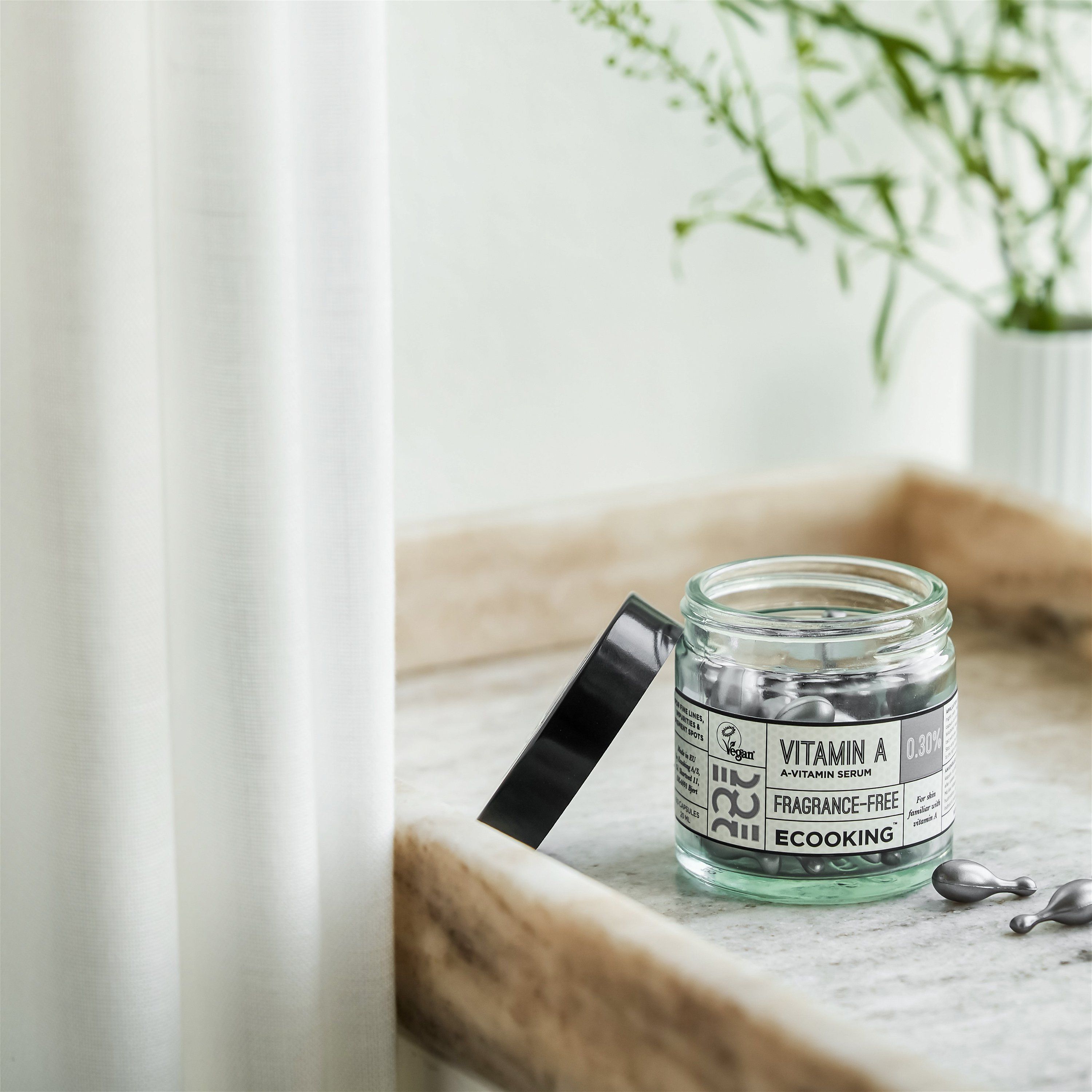 Glas mit Kapseln, Deckel daneben. Aufschrift: Vitamin A 0,30%, Fragrance-Free, Ecooking. Vegan-Siegel.