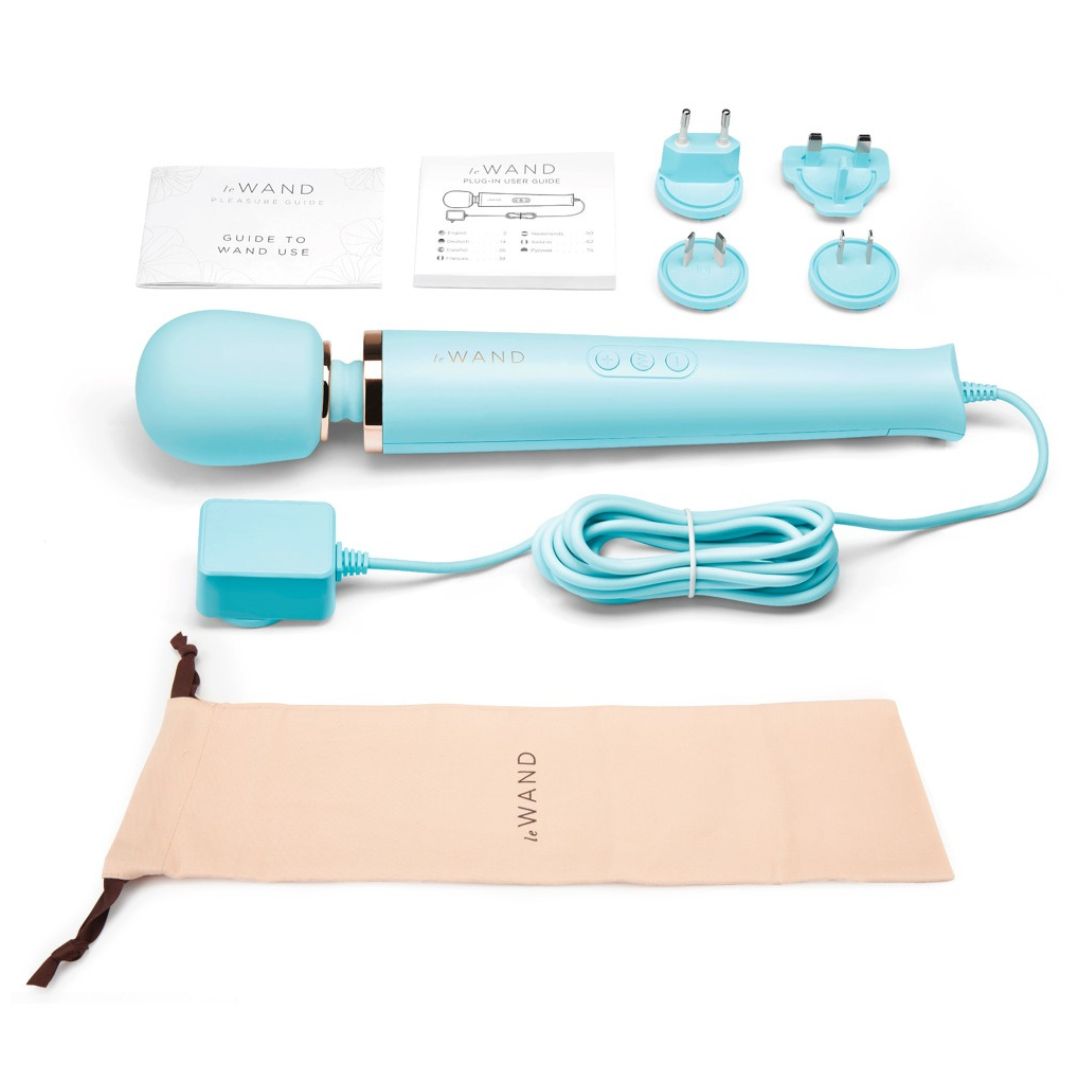 Hellblaues Massagegerät mit Zubehör: Netzteile, Anleitung, Beutel. "Le Wand" ist sichtbar.