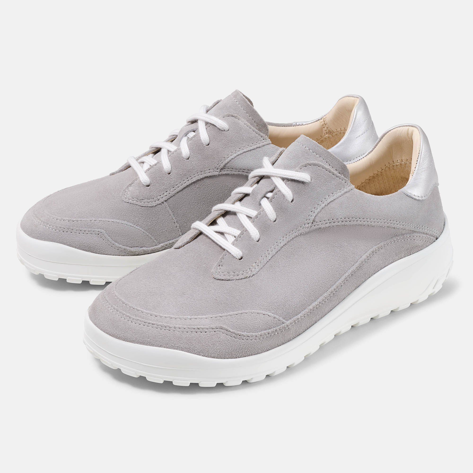 Graue Schnürschuhe mit weißer Sohle. Silberfarbene Akzente an der Ferse. Hellgraues Wildleder-Obermaterial. Schnürsenkel.