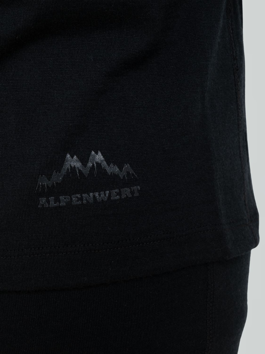 Detailansicht des Logos auf einem schwarzen Herren-Merino-Pullover.