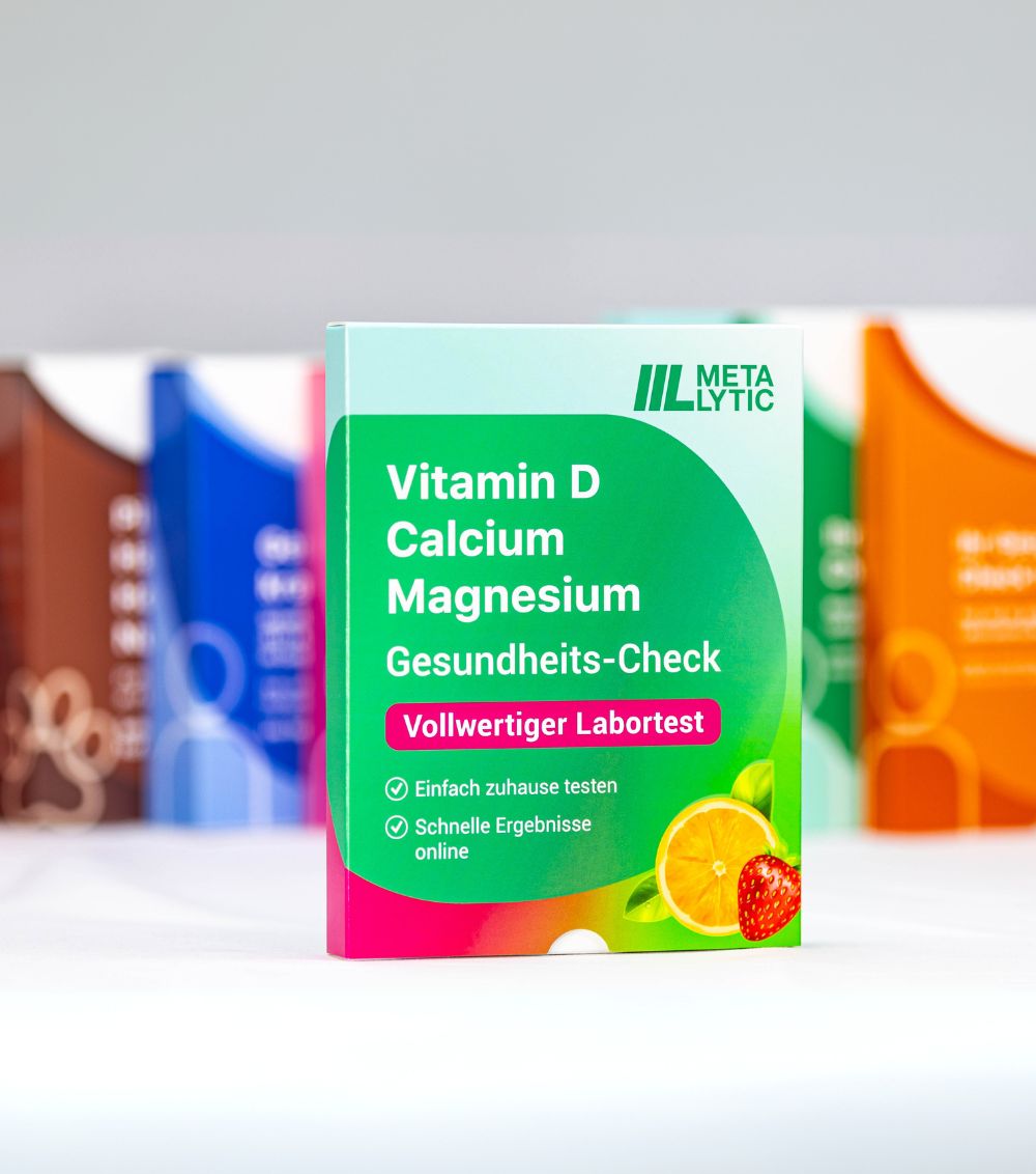 Mehrere Testboxen im Hintergrund. Vordergrund: Box mit Aufschrift: Vitamin D, Calcium, Magnesium, Gesundheits-Check. Logo: Metalyic.