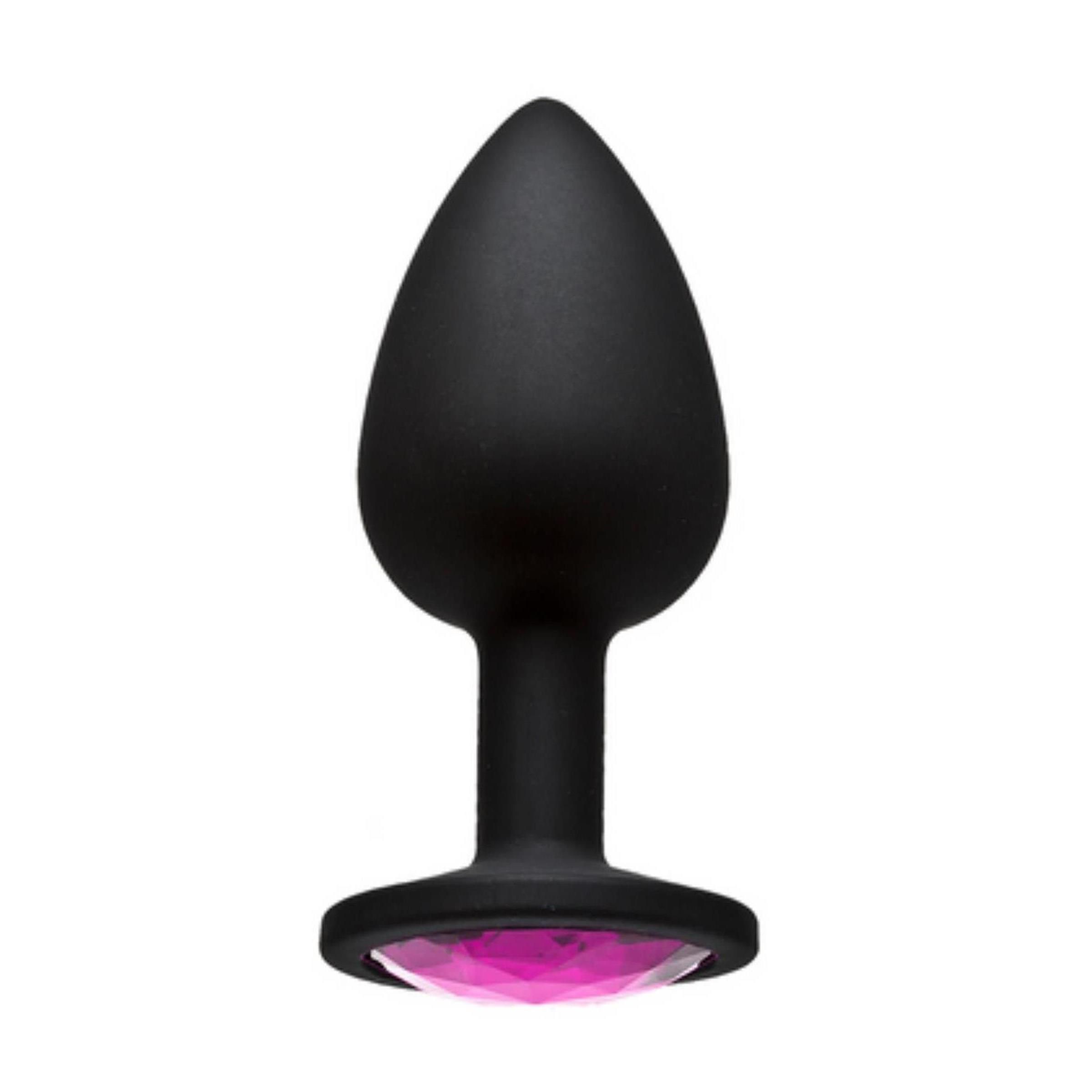Schwarzer, spatenförmiger Plug mit rosa Schmuckstein an der Basis. Der Plug steht aufrecht.