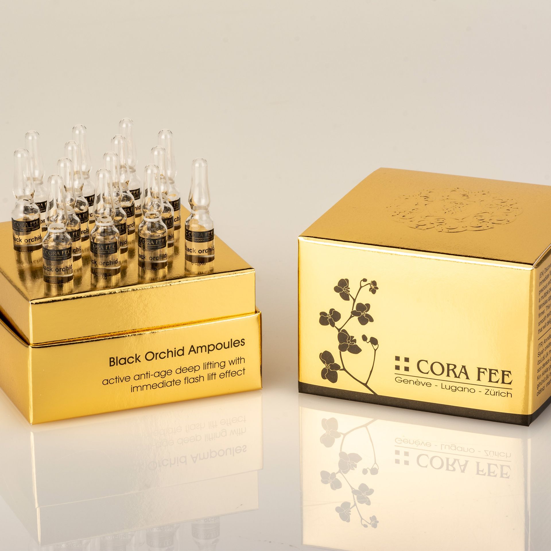 Zwei goldfarbene Schachteln mit Ampullen. Text: Black Orchid Ampoules, Cora Fee. Ampullen in der Schachtel.