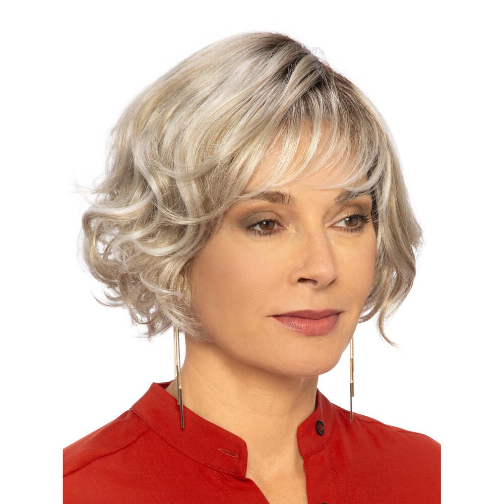Perücke Biarritz von DELUXE. Blond gewellt, mit Pony. Frau mit roter Bluse. Frontansicht.