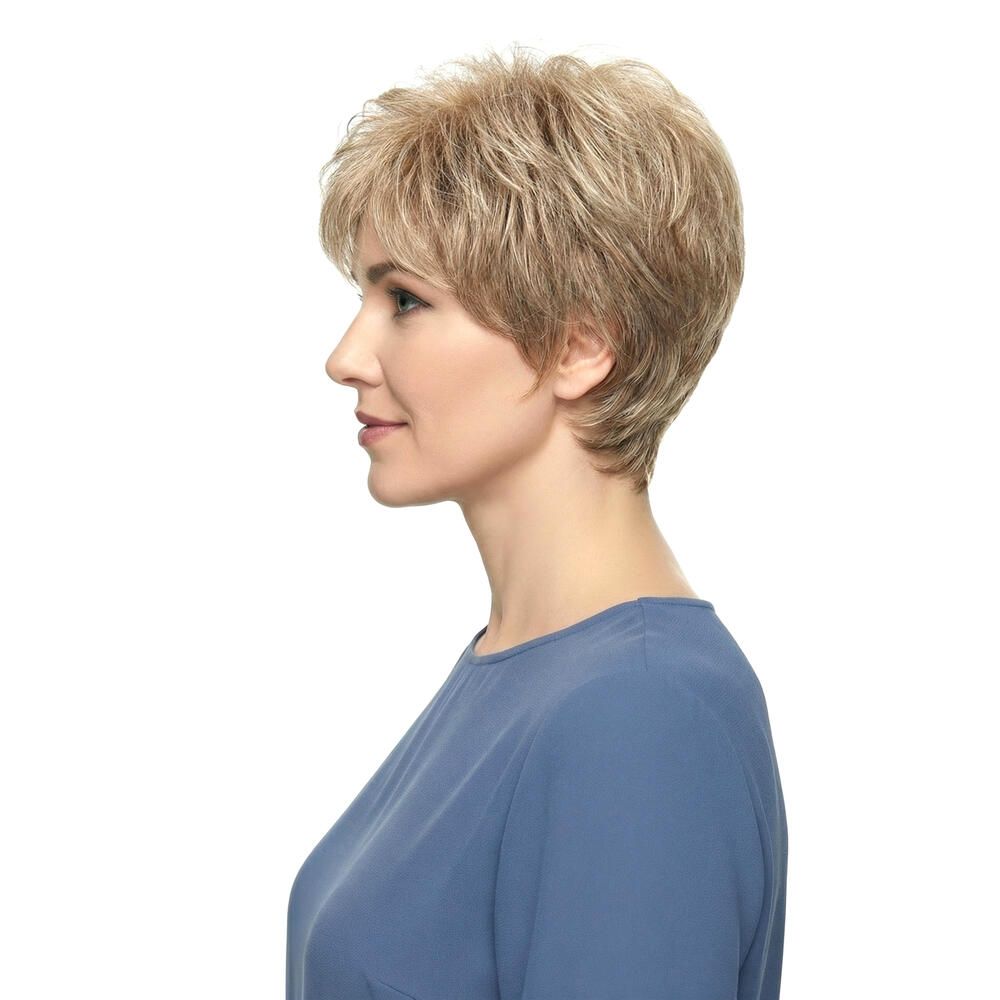 Kurzhaarperücke in Blondtönen. Seitenansicht einer Frau mit blauer Bluse. Die Perücke hat einen kurzen, fransigen Schnitt.