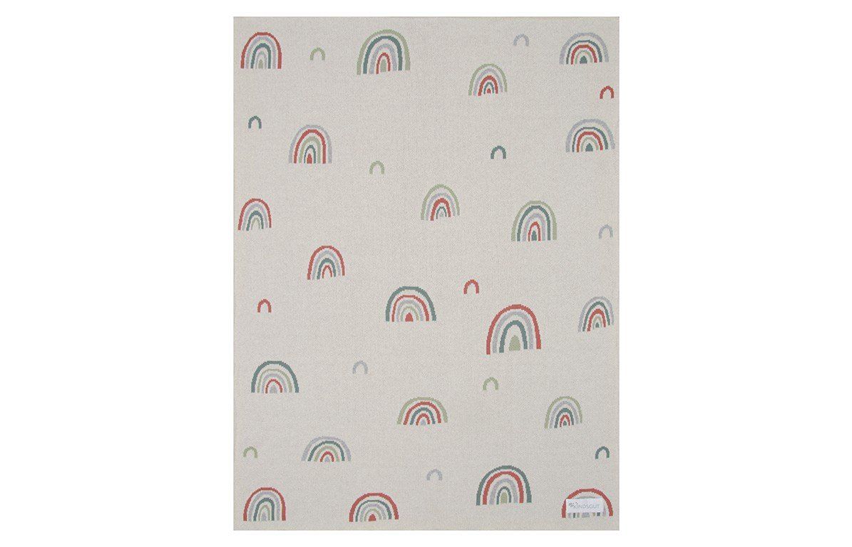 Eine Decke mit Regenbogenmuster. Beige mit bunten Regenbogenmotiven. Das Muster bedeckt die gesamte Oberfläche.