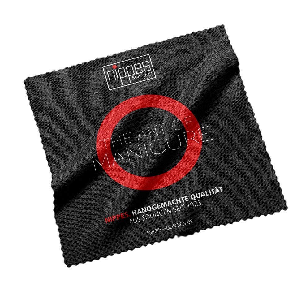 Schwarzes Mikrofasertuch mit rotem Kreis und Text: The Art of Manicure. Nippes Solingen.