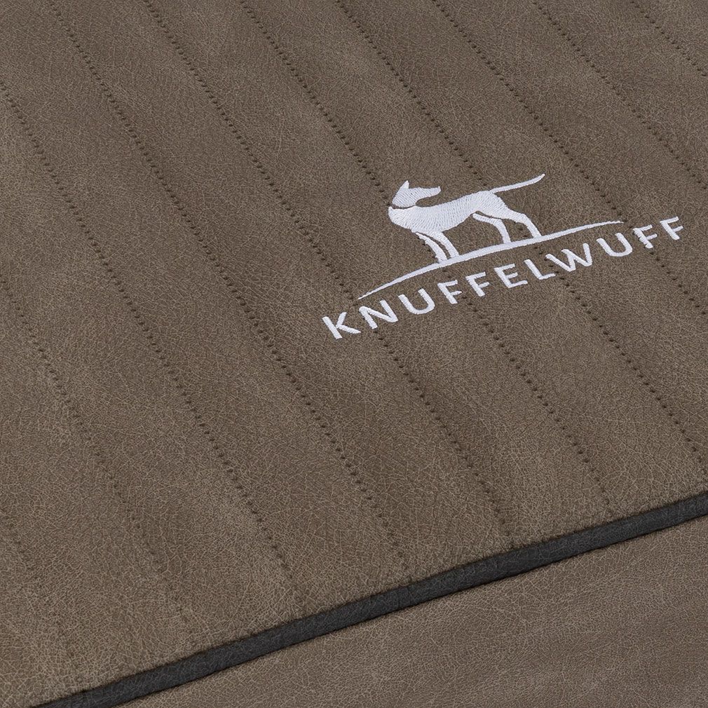 Detailansicht der orthopädischen Hundematte Palomino. Braunes Material mit Steppnähten. Knuffelwuff Logo.