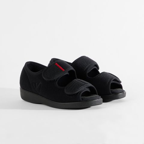Schwarze Komfortschuhe mit Klettverschluss und roter Zierleiste.