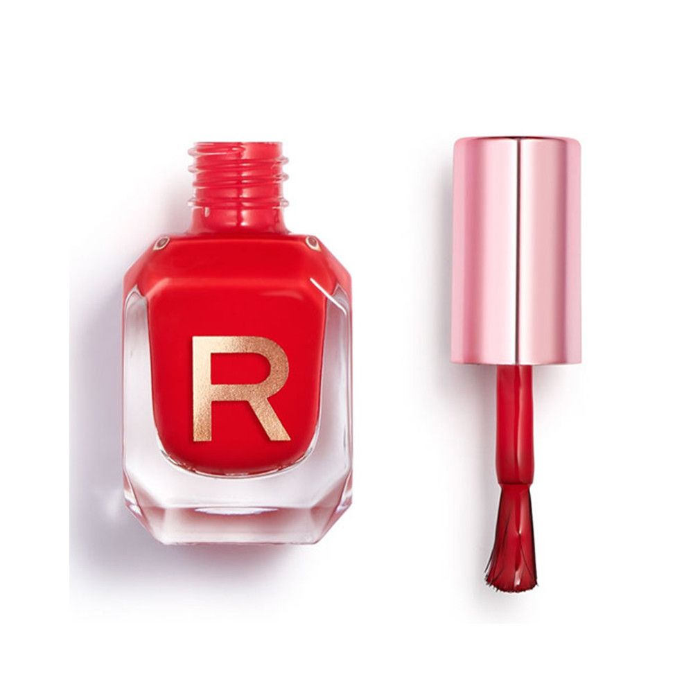 Roter Nagellack in einem durchsichtigen Flakon mit goldener "R"-Prägung und roségoldenem Applikator.