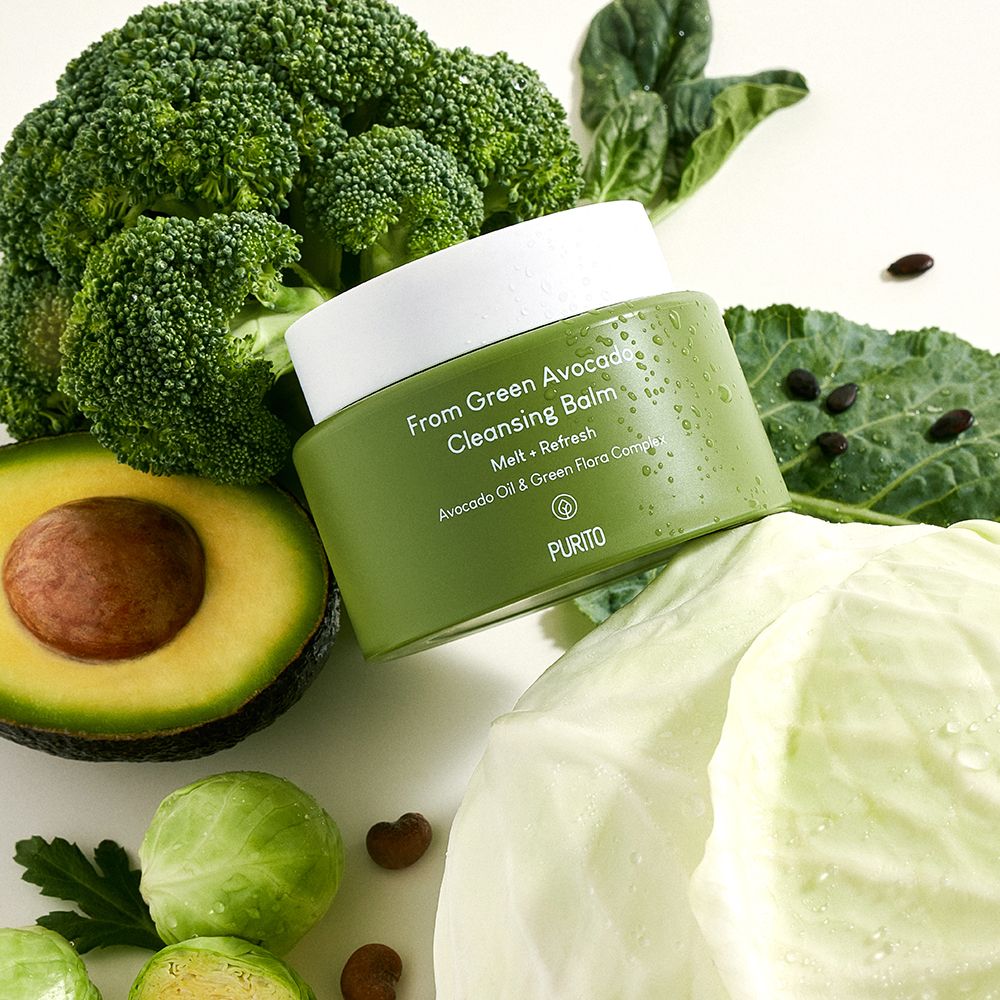 Grüner Tiegel umgeben von Brokkoli, halber Avocado und Kohl.