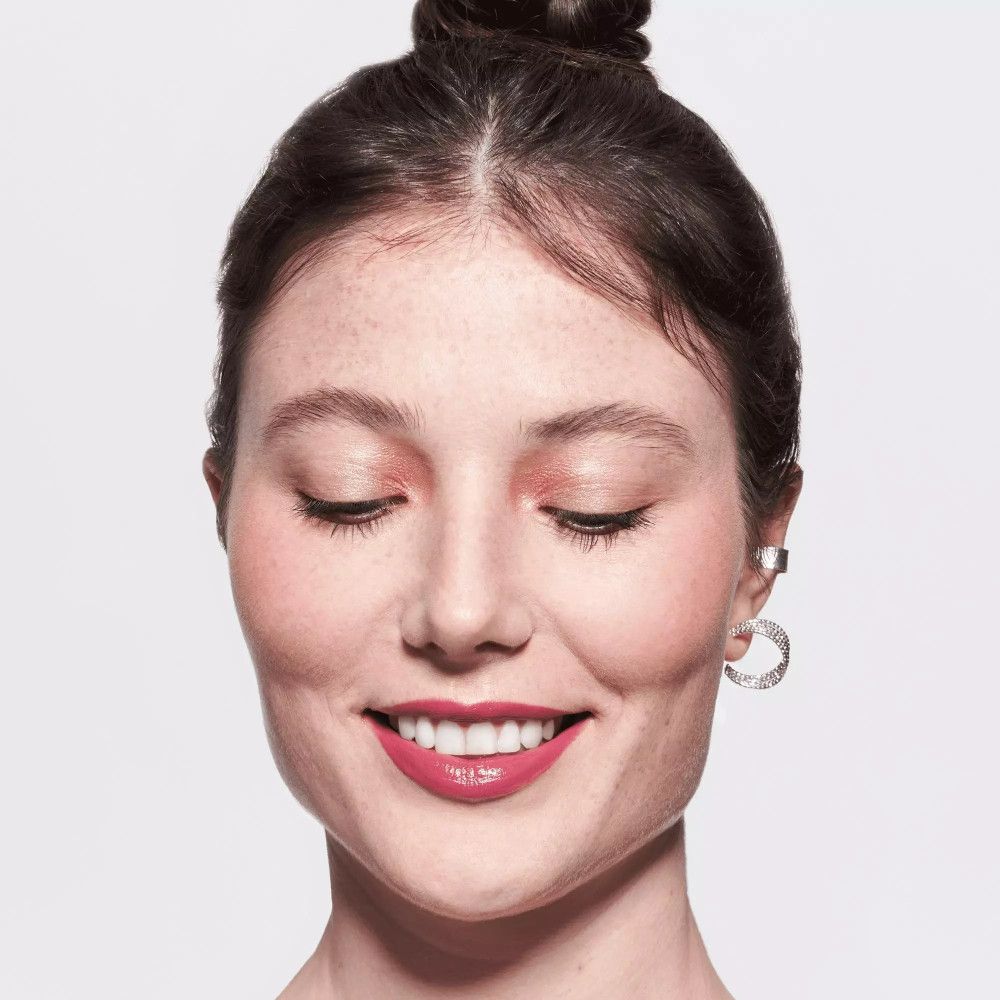 Porträt einer Frau mit rosa Lippen. Hochgesteckte Haare, silberner Ohrring. Geschlossene Augen.