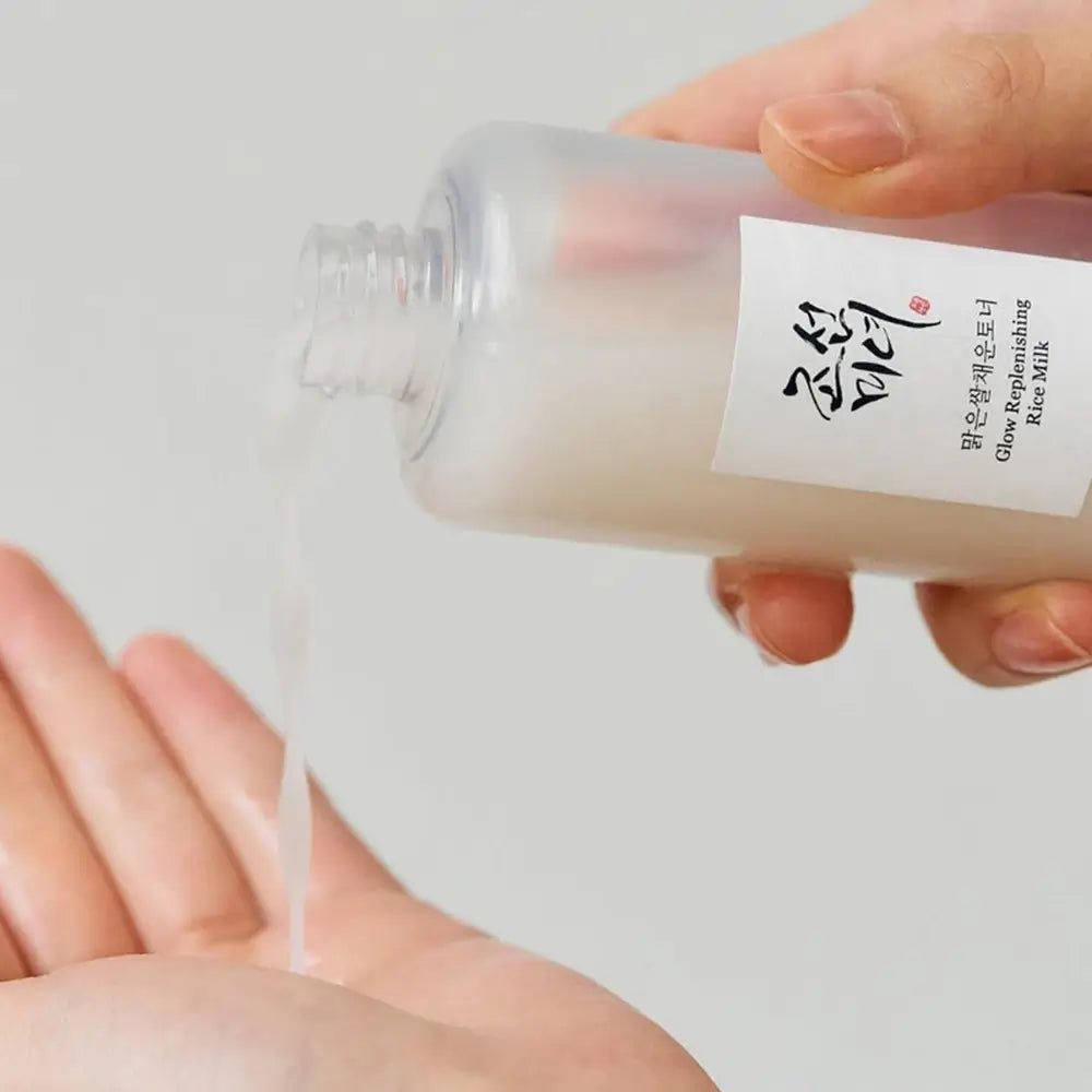 Hände halten eine Flasche, aus der Flüssigkeit fließt. Etikett mit Text.