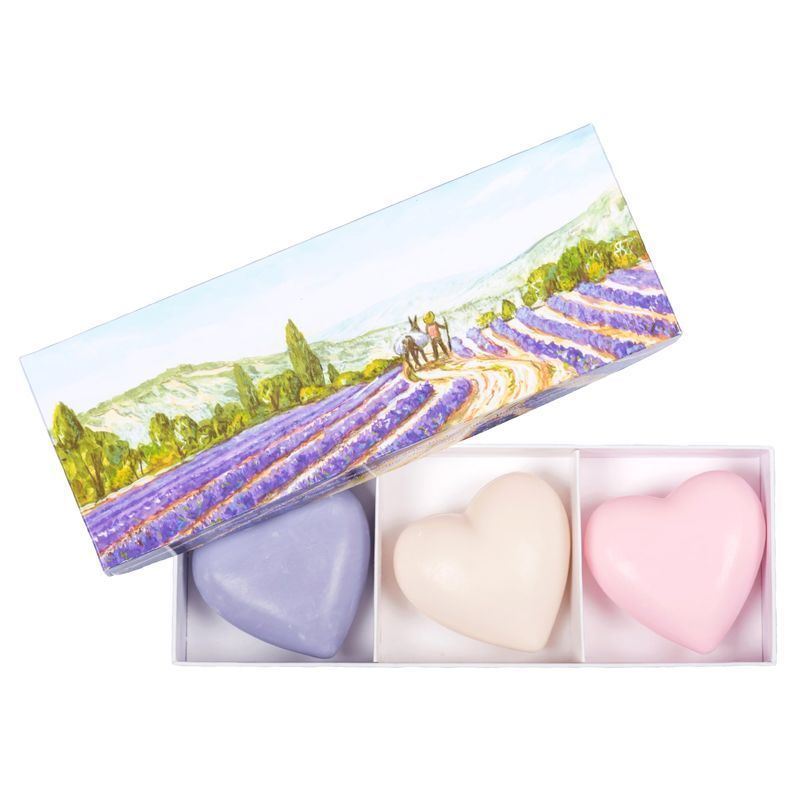 Drei herzförmige Seifen in einer Schachtel. Farben: Lila, Weiß und Rosa. Deckel mit Lavendelfeld-Motiv.