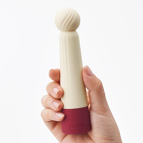 Weiß-roter Vibrator in einer Hand gehalten. Kugelförmiger Kopf mit Rillen, roter Sockel mit "iroha"-Schriftzug.