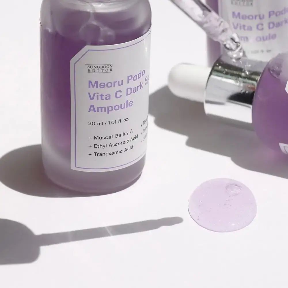 Zwei violette Flaschen mit weißen Etiketten. Produktnamen und Inhaltsstoffe sind aufgedruckt. Pipetten.