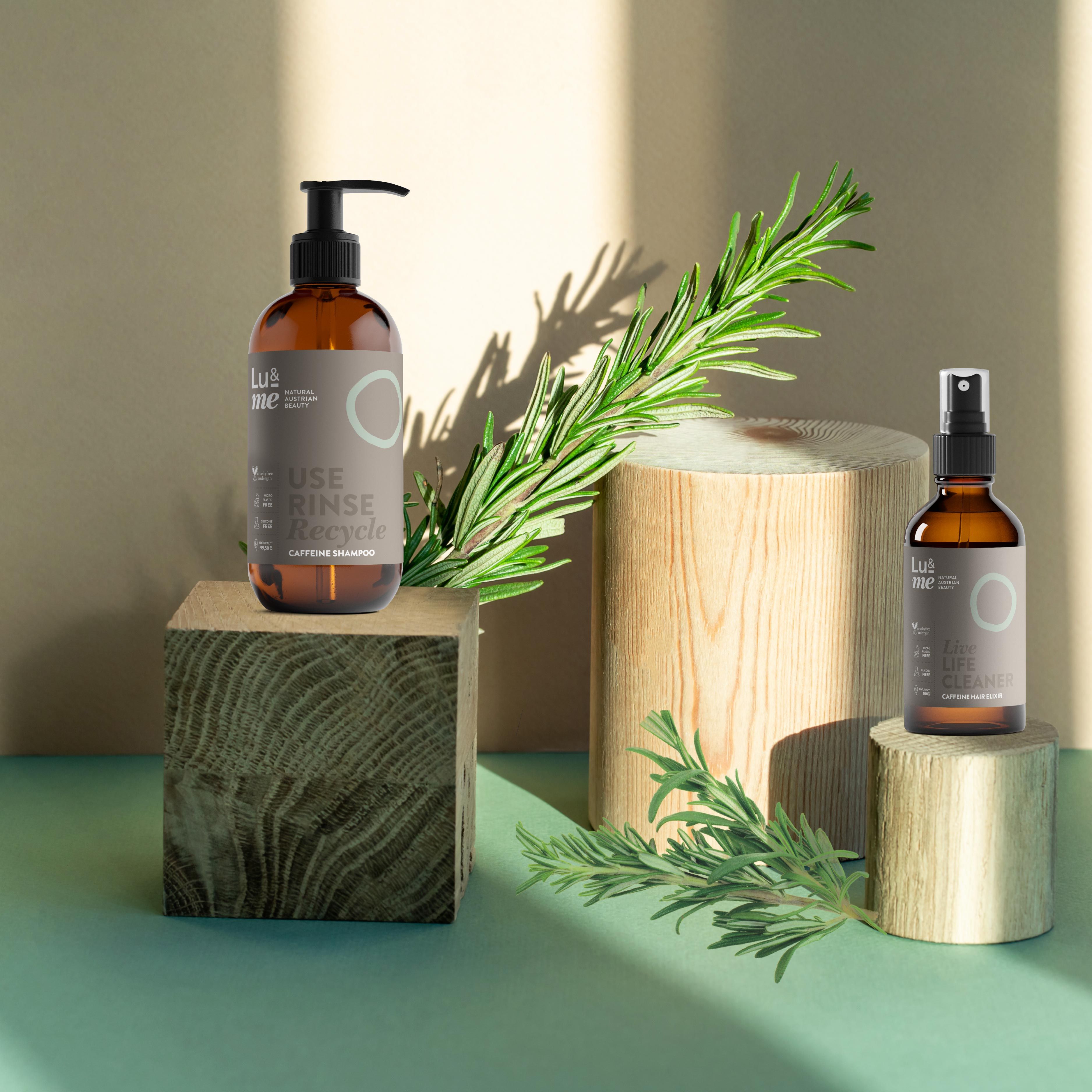 Braune Flasche mit Pumpe, braune Sprühflasche, Rosmarinzweig auf Holzblöcken. Text: Lu&me.