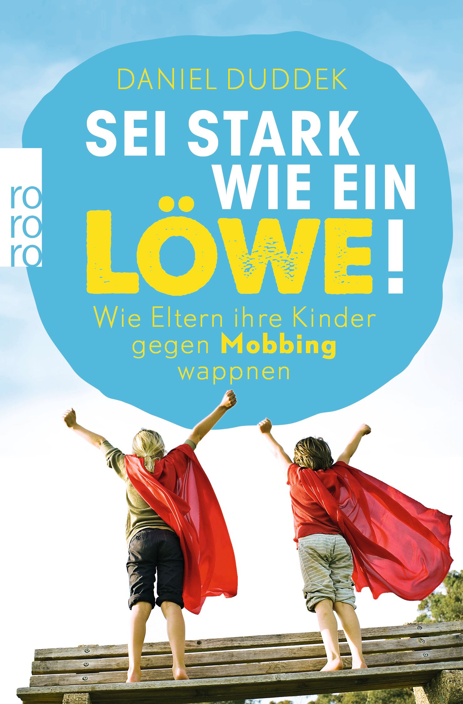 Buchcover mit Titel: Sei stark wie ein Löwe! Zwei Kinder mit roten Umhängen stehen auf einer Bank.