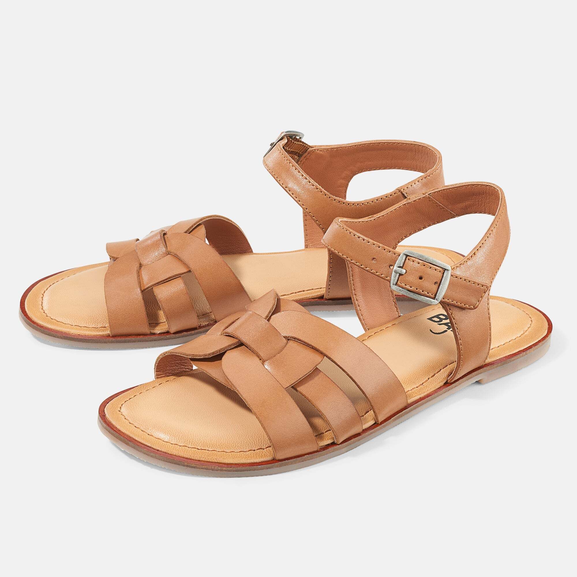 Braune Sandalen mit geflochtenem Riemen und Schnalle. Flache Sohle. Zwei Sandalen nebeneinander.