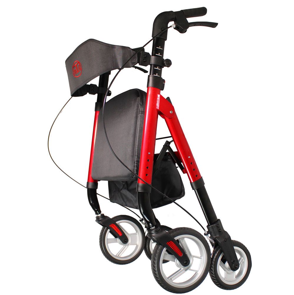 Gefalteter Rollator mit rotem Rahmen, schwarzem Sitz und Rückenlehne. Vier Räder, Einkaufstasche und Handbremsen.