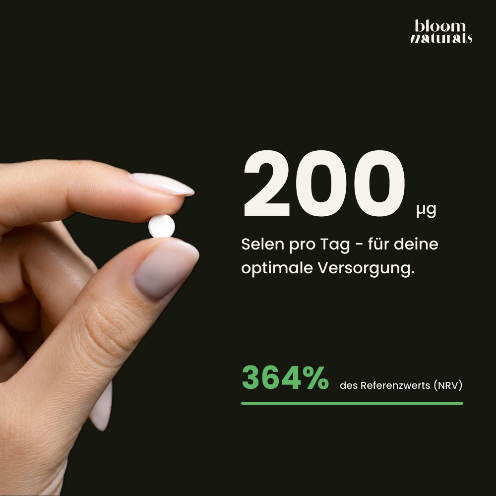 Finger hält eine kleine weiße Selen-Tablette. 200µg Selen pro Tag.