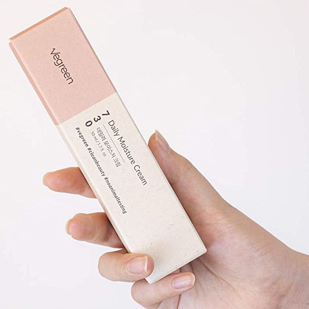 Produktverpackung in Hand gehalten. Aufschrift: VEGREEN 730 Daily Moisture Cream. Rosa und beige.