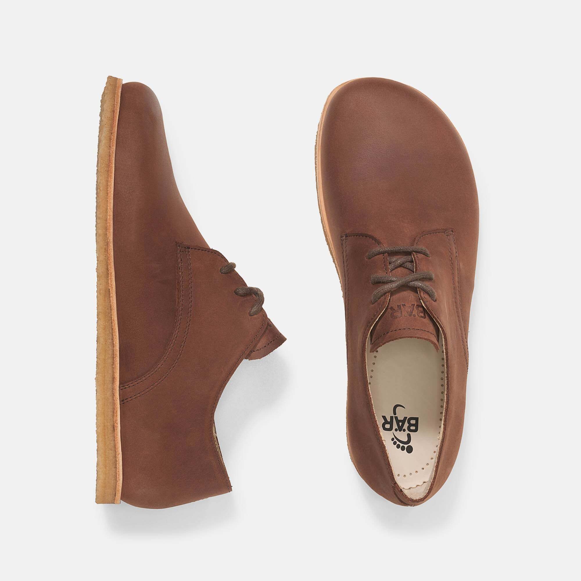 Zwei braune Lederschnürschuhe, einer von oben, einer von der Seite. Helle Sohle. Innensohle mit Logo.