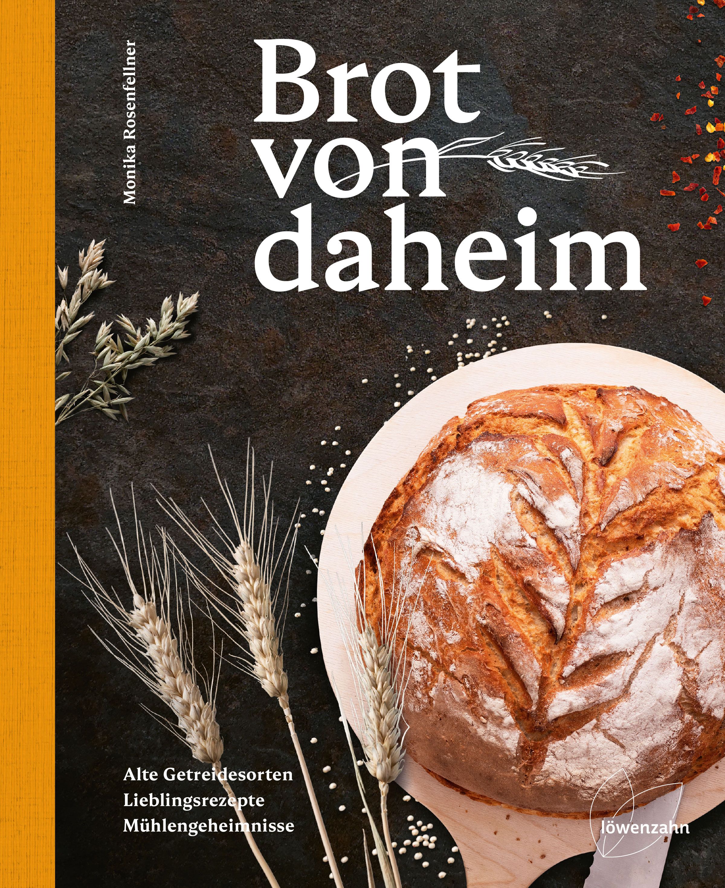 Buchcover mit Brot von daheim. Titel in weißer Schrift. Darunter ein Brotlaib auf Holzbrett. Weizenähren und Textur im Hintergrund.