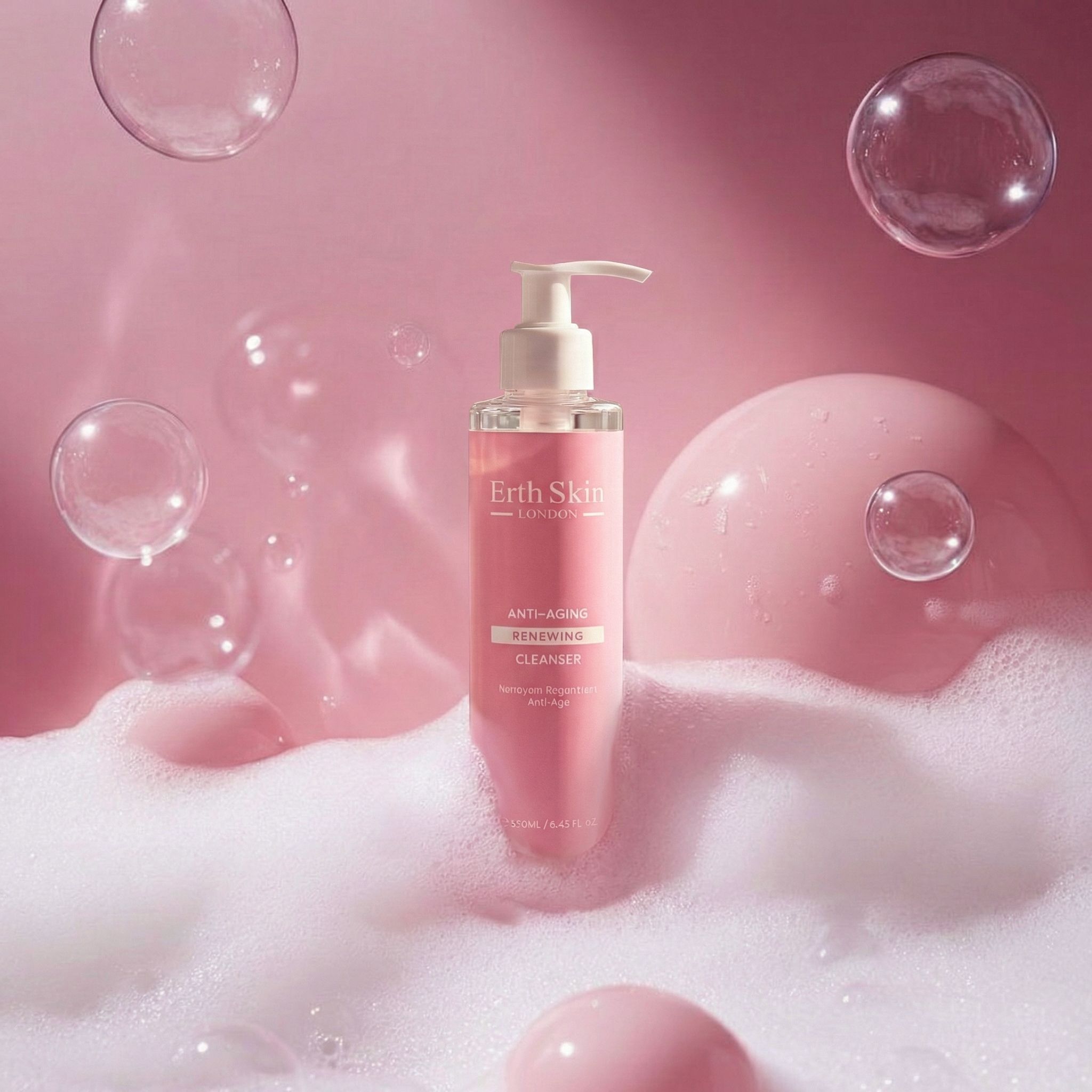 Rosa Flasche mit Pumpe in Seifenblasen. Aufschrift: Erth Skin London, Anti-Aging Renewing Cleanser. Rosa Hintergrund.