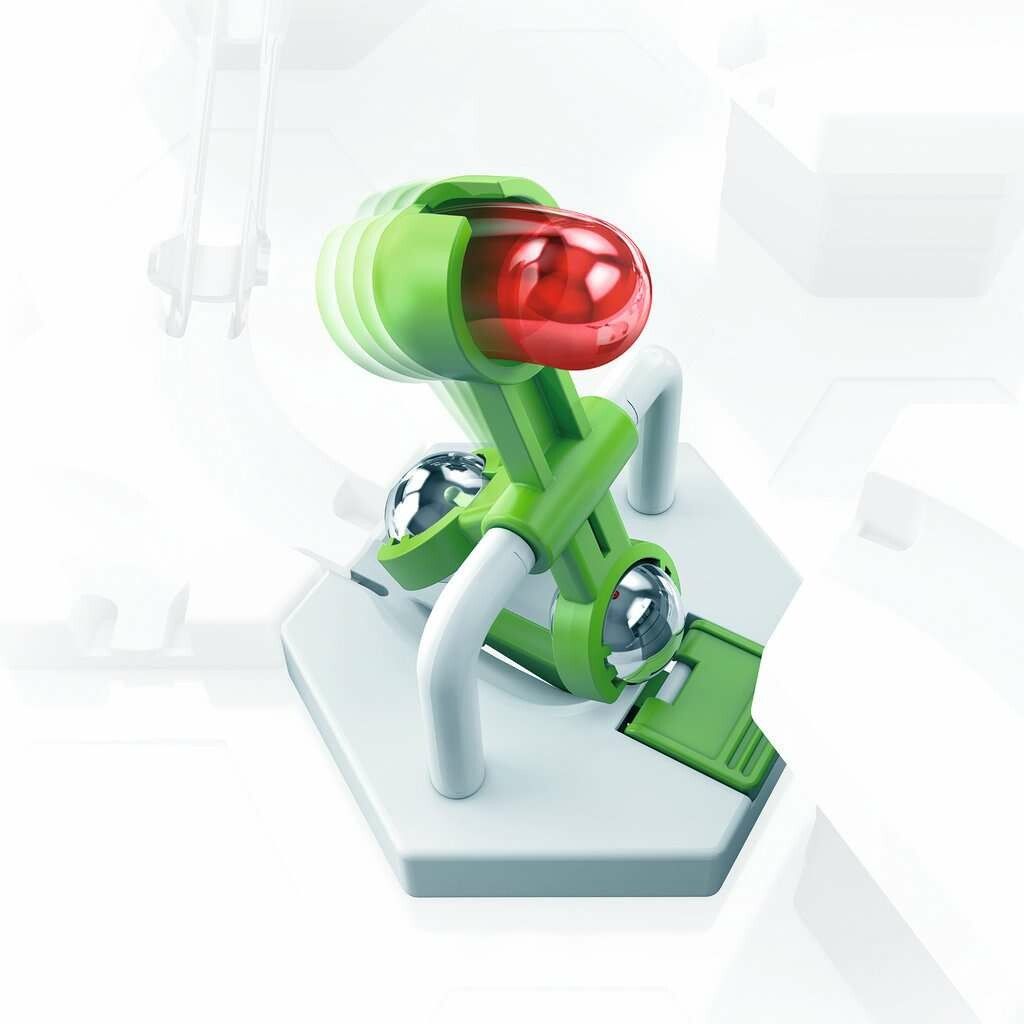 Il GraviTrax Element Scoop, un meccanismo verde con una sfera rossa e sfere argentate. Poggia su una base esagonale bianca con supporti bianchi. Gli elementi sono progettati per il sistema GraviTrax per controllare il movimento delle sfere.