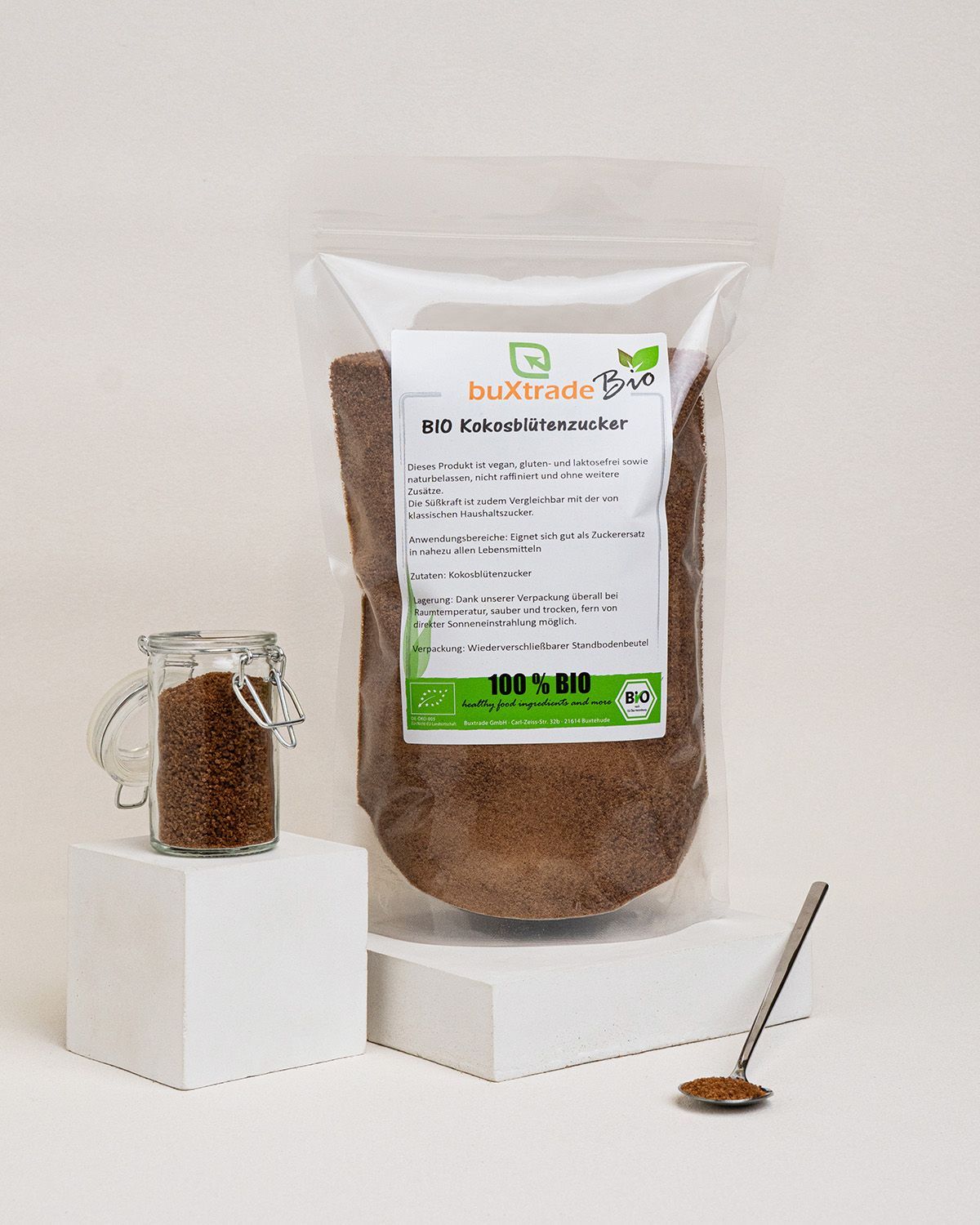 Verpackung mit Kokosblütenzucker, ein Glas Zucker und ein Löffel mit Zucker.