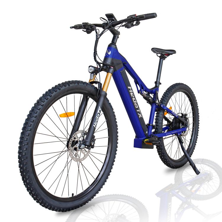 Blaues E-Mountainbike HedaTX TX19. Schwarze Reifen, goldene Gabel, schwarzer Sattel. Aufschrift HedaTX. Schräge Frontansicht.