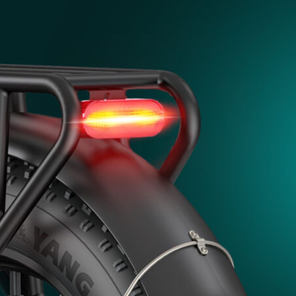 Rücklicht eines schwarzen Fahrrads. Rotes Licht, montiert an einem Gepäckträger. Schwarzer Reifen mit Aufschrift.