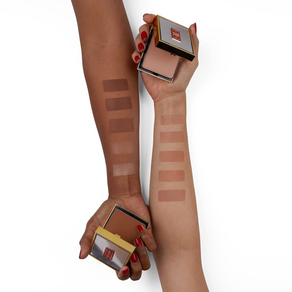 Hände mit Make-up-Farbmustern auf dem Arm. Goldene Kompakt-Make-up-Dosen.