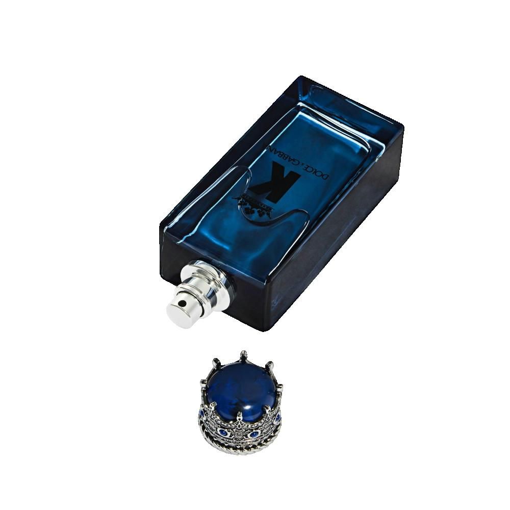 Flache, blaue Glasflasche mit silbernem Sprühkopf und abgenommenem Kronenverschluss.