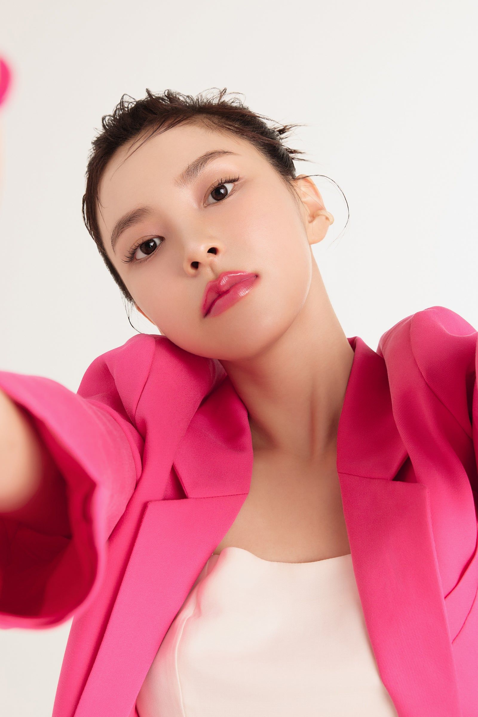Frau mit pinkfarbenem Blazer und Lippenstift. Nahaufnahme.