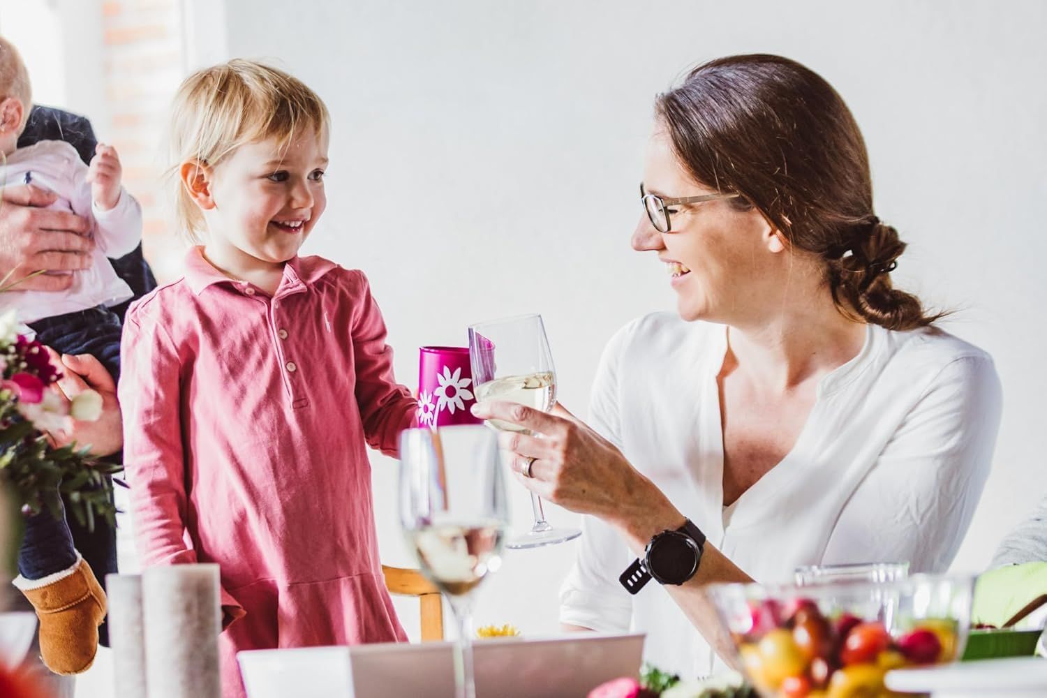 Frau und Kind stoßen mit Gläsern an.