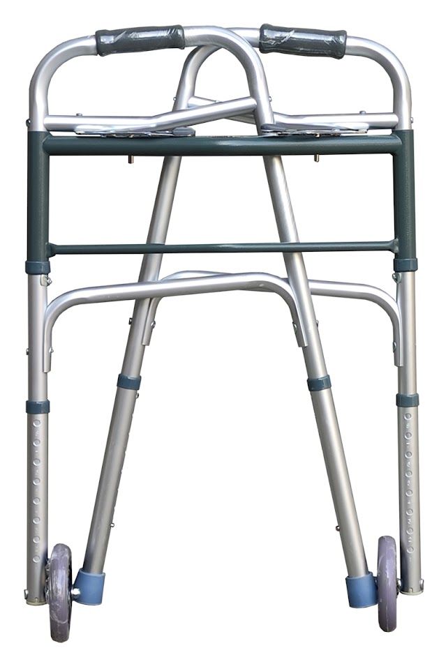 Opgevouwen rollator met wielen en doppen. Zilverkleurig aluminium frame met groene accenten. Grijze handgrepen.