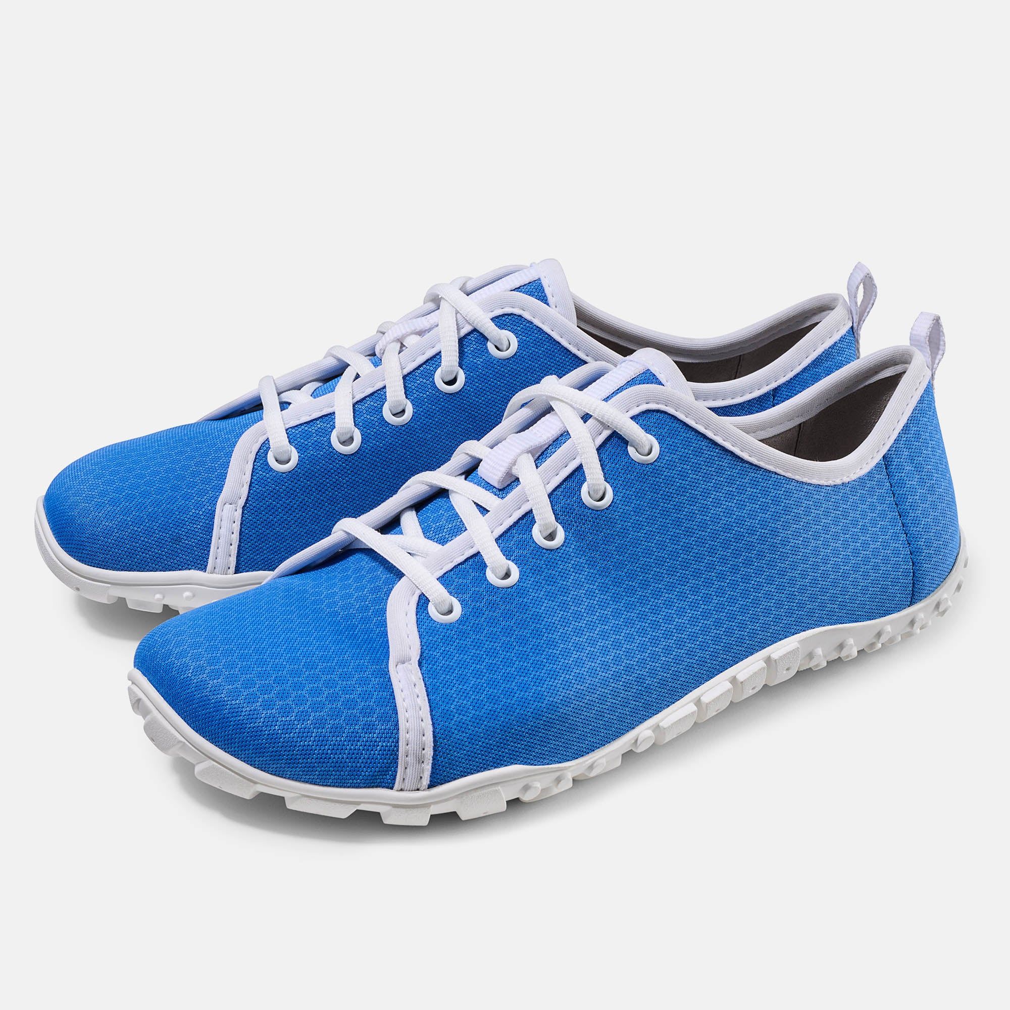 Blaue Schnürschuhe mit weißer Schnürung und Sohle. Hellblauer Stoff mit Wabenmuster. Breite Passform.